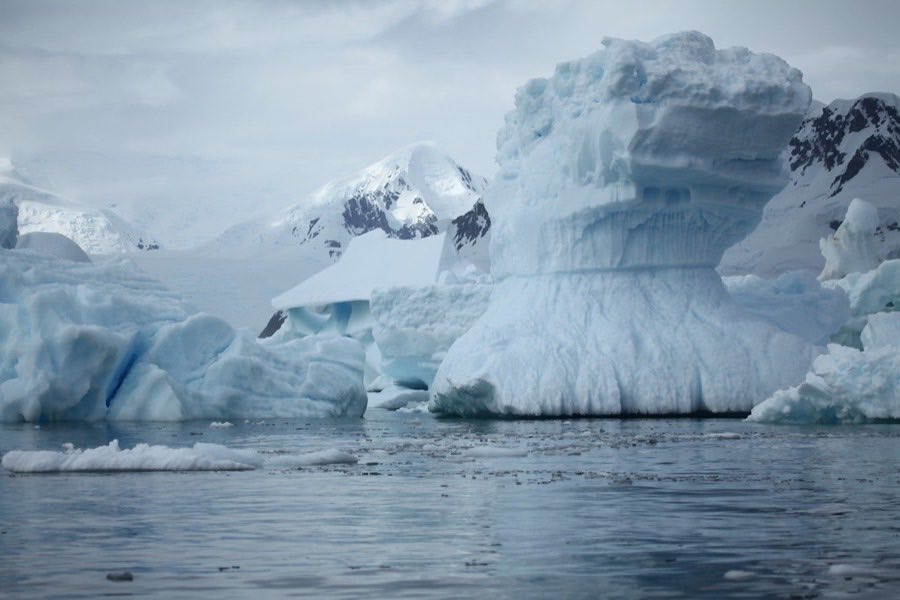 Antarctic icebergs and mountains beside a cold ocean